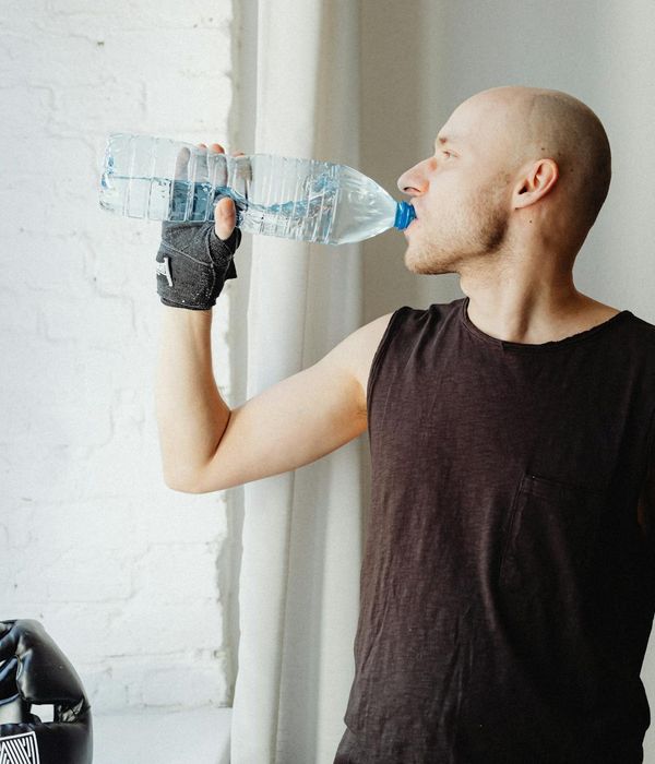 Man performing a controlled strength exercise in a minimalist gym setting.